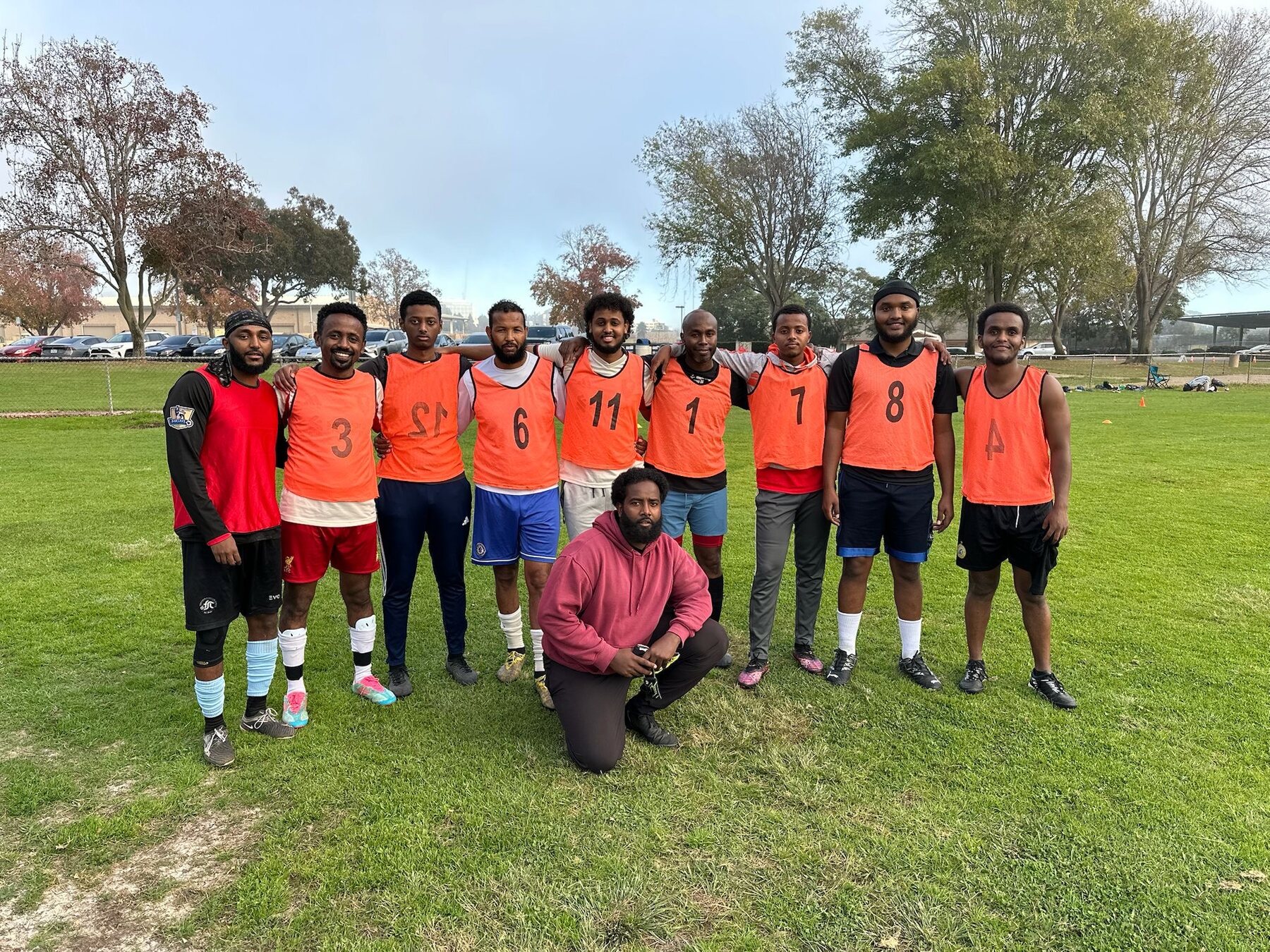 Orange team gathered on a community soccer field
