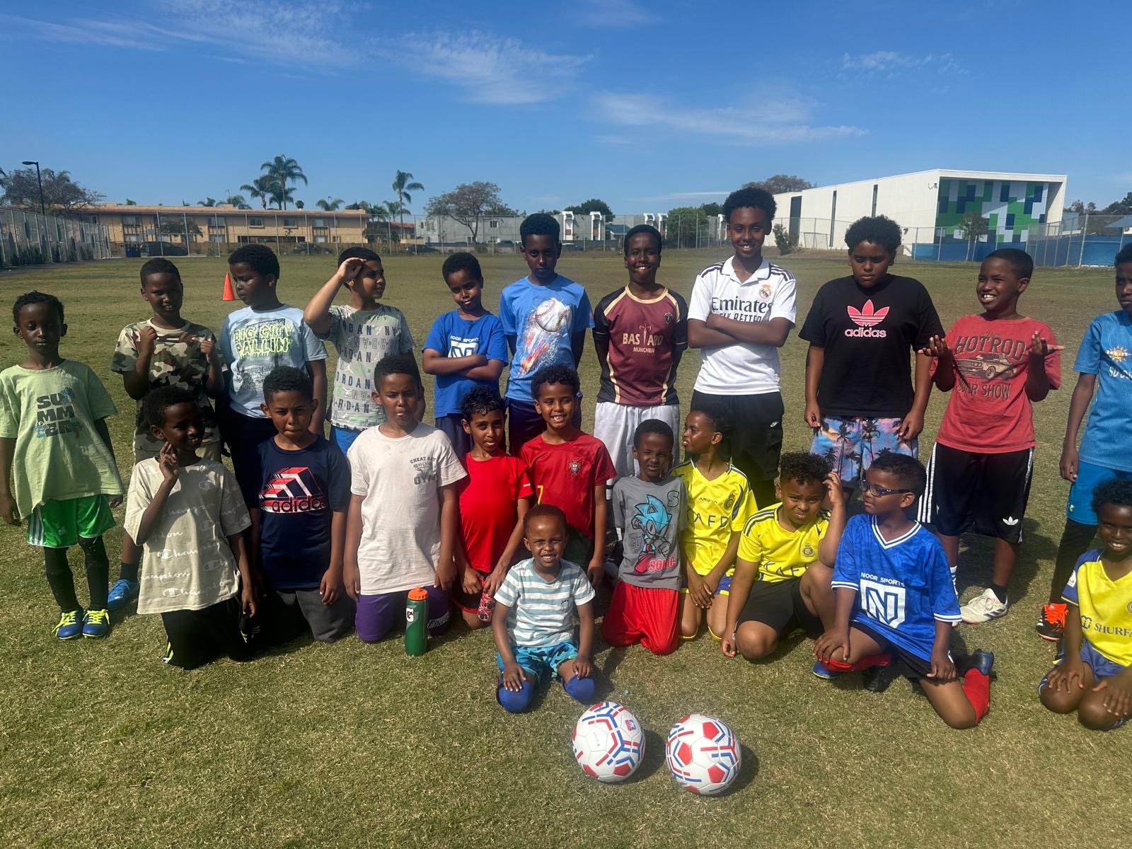Youth soccer group posing with two soccer balls