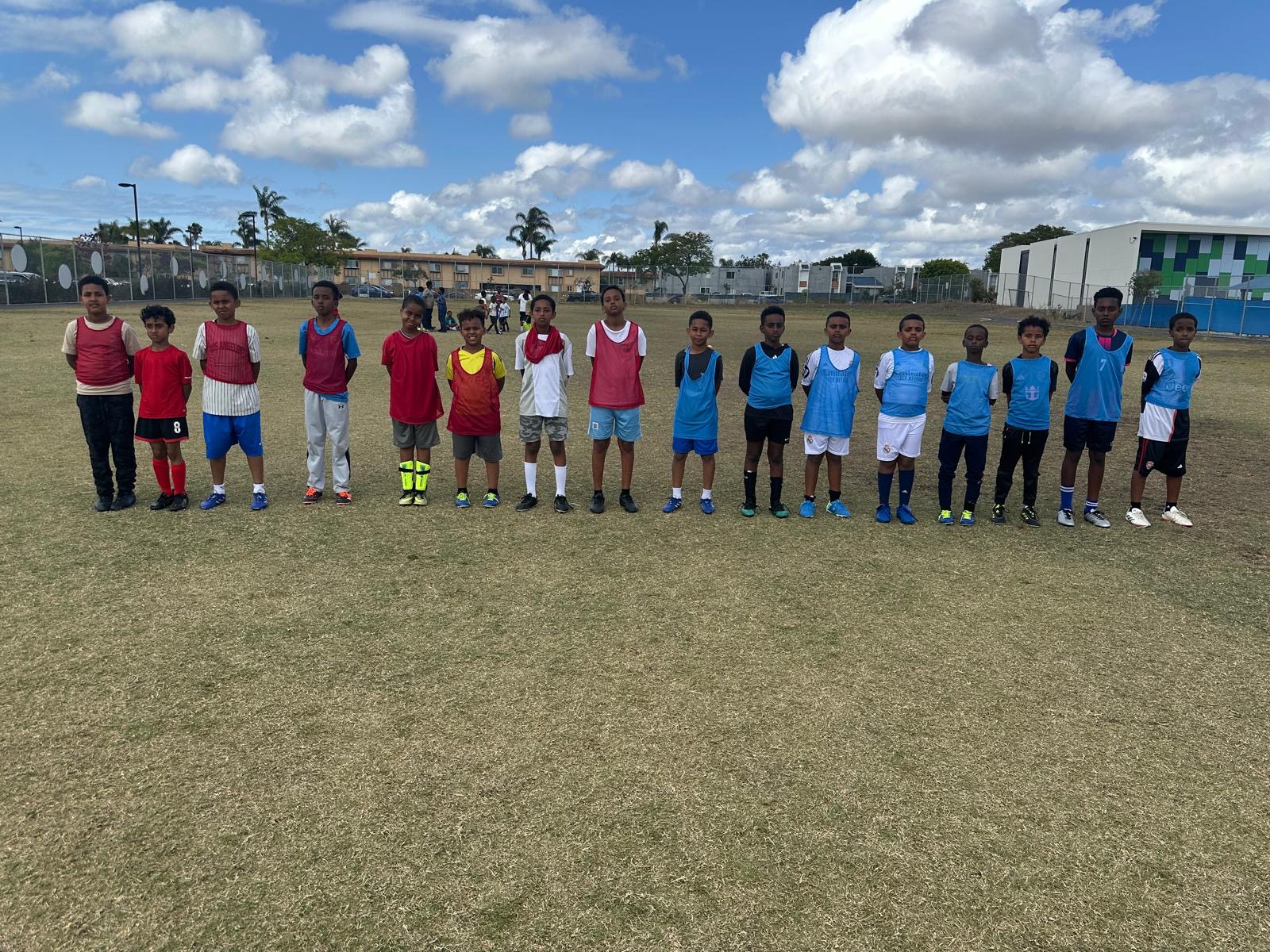 Youth players lined up across the soccer field